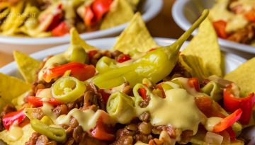 Nachos mit Linsenbolognese und Käsesauce sowie Peperonis und Paprika