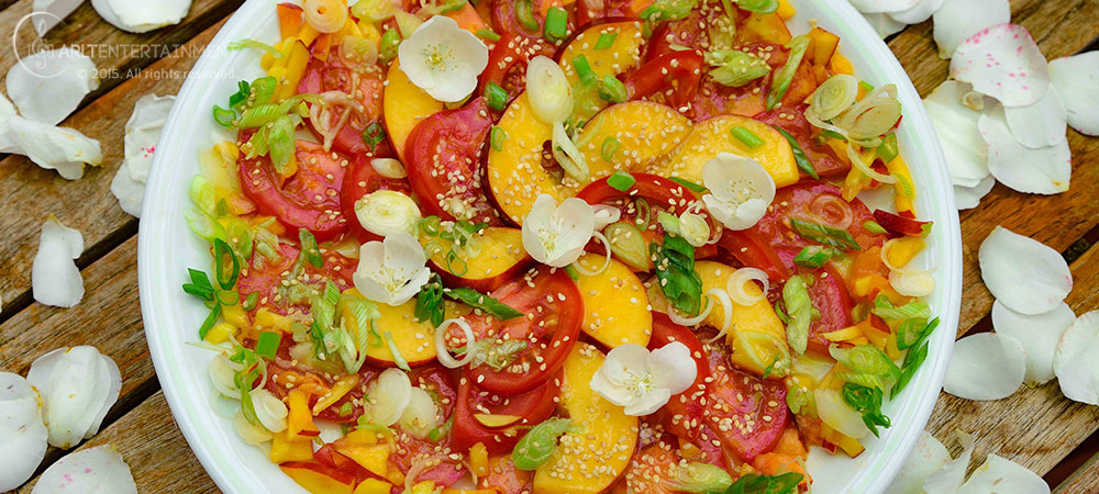 Bunter Salat aus Nektarinen und Tomaten auf einem weissen Teller